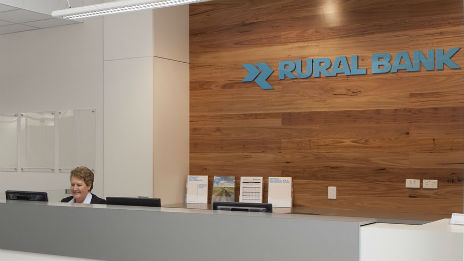 Staff member sitting at desk in Rural Bank branch.