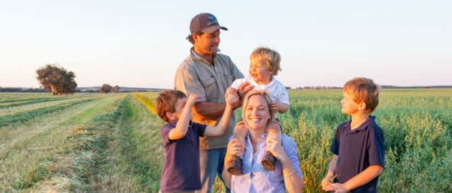 Parents and three children playing in paddock.