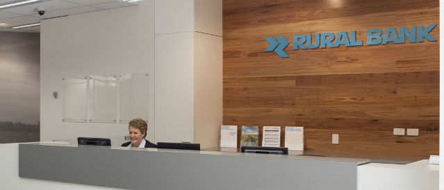 Staff member sitting at desk in Rural Bank branch.